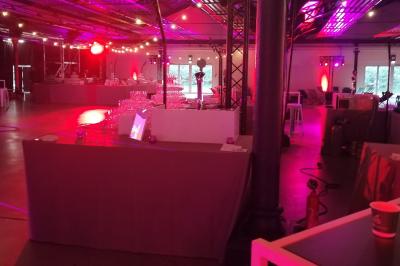 Baby-foot géant installé dans un espace intérieur avec éclairage tamisé et tables hautes en arrière-plan.