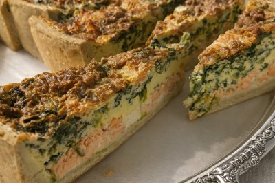 Petits pains garnis de pastrami, germes de luzerne et graines noires, disposés sur un plateau en métal.