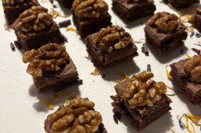 Petits pains garnis de pastrami, germes de luzerne et graines noires, disposés sur un plateau en métal.