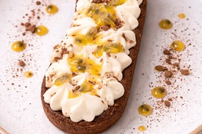 Petits pains garnis de pastrami, germes de luzerne et graines noires, disposés sur un plateau en métal.