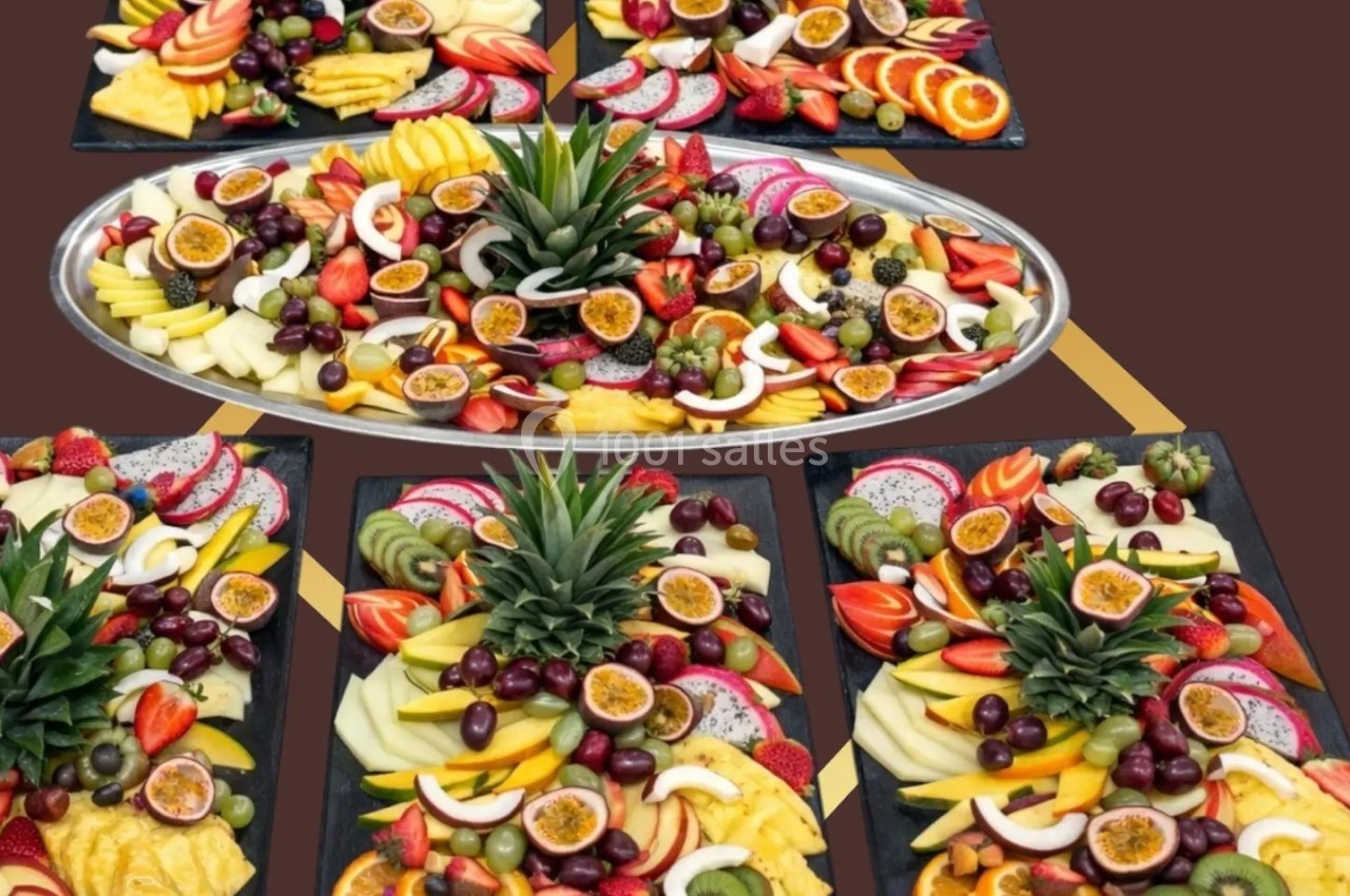 Plateaux de fruits variés avec ananas, kiwis, fruits de la passion, raisins, oranges et autres fruits frais.