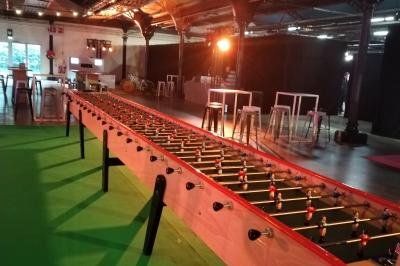 Salle de réception décorée avec des lumières colorées, des tables dressées et un éclairage tamisé.