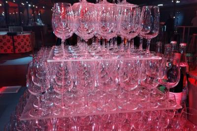 Salle de réception décorée avec des lumières colorées, des tables dressées et un éclairage tamisé.