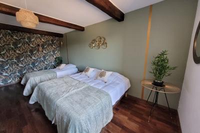 Miniature Location salle Peyruis (Alpes-de-Haute-Provence) - Les Grandes Mollières #21 Chambre lumineuse avec lit double, murs beige et blanc, parquet, miroir mural et table de chevet en bois.