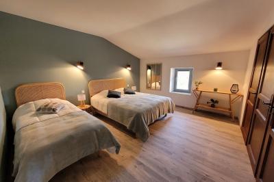 Miniature Location salle Peyruis (Alpes-de-Haute-Provence) - Les Grandes Mollières #27 Chambre lumineuse avec lit double, murs beige et blanc, parquet, miroir mural et table de chevet en bois.