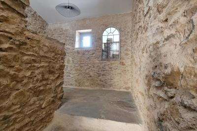 Miniature Location salle Peyruis (Alpes-de-Haute-Provence) - Les Grandes Mollières #18 Chambre lumineuse avec lit double, murs beige et blanc, parquet, miroir mural et table de chevet en bois.