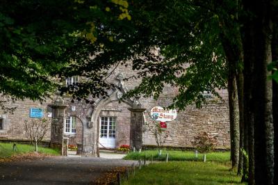 Miniature Location salle La Forêt-Fouesnant (Finistère) - Manoir du Stang #7 Façade éclairée d'un grand bâtiment en pierre de style ancien, entouré d'une pelouse, de nuit.
