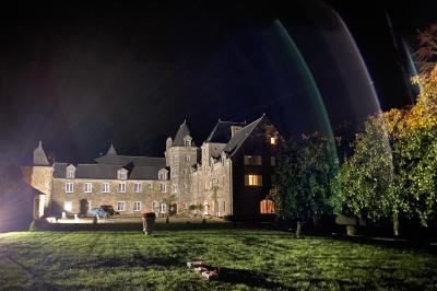 Miniature Location salle La Forêt-Fouesnant (Finistère) - Manoir du Stang #10 Façade éclairée d'un grand bâtiment en pierre de style ancien, entouré d'une pelouse, de nuit.