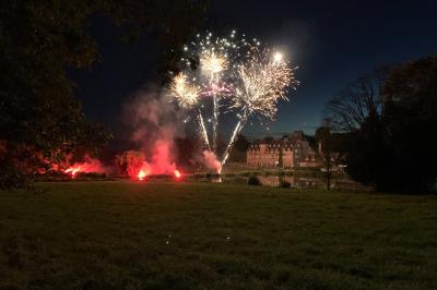 Miniature Location salle La Forêt-Fouesnant (Finistère) - Manoir du Stang #3 Façade éclairée d'un grand bâtiment en pierre de style ancien, entouré d'une pelouse, de nuit.