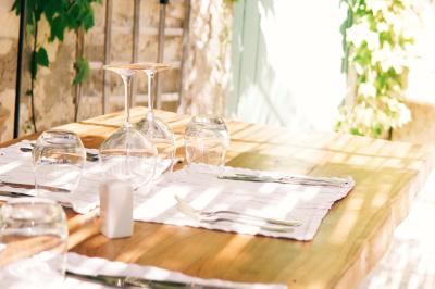 Vue d'une chambre cosy avec lit, éclairage doux, rideaux verts et table extérieure ornée de plantes et d'une tasse.