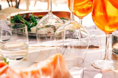 Vue d'une chambre cosy avec lit, éclairage doux, rideaux verts et table extérieure ornée de plantes et d'une tasse.