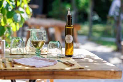 Vue d'une chambre cosy avec lit, éclairage doux, rideaux verts et table extérieure ornée de plantes et d'une tasse.