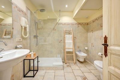 Vue d'une chambre cosy avec lit, éclairage doux, rideaux verts et table extérieure ornée de plantes et d'une tasse.