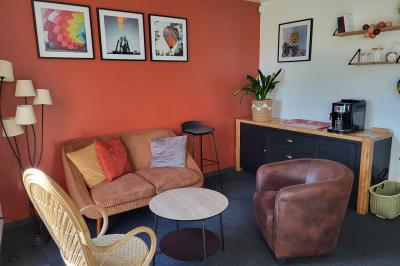 Vue aérienne d'une campagne verdoyante avec champs, haies, étangs et un village sous un ciel bleu dégagé.