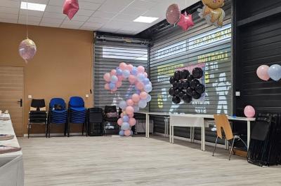 Table décorée pour une fête avec nappes noires, assiettes jaunes, gobelets, bonbons et motifs sur le thème du football.