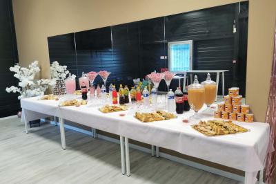 Table décorée pour une fête avec nappes noires, assiettes jaunes, gobelets, bonbons et motifs sur le thème du football.