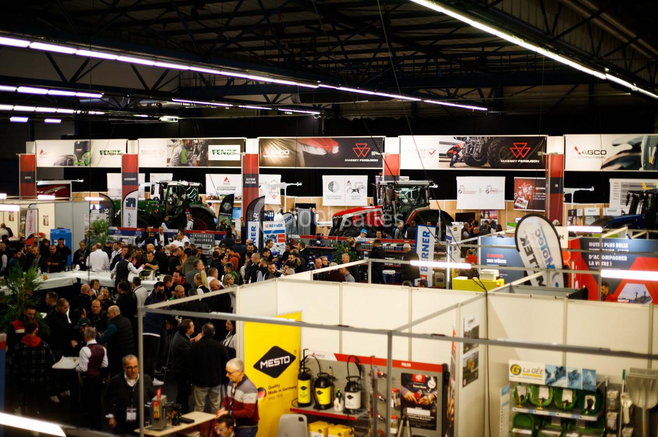 Vue d'un salon professionnel avec des stands exposant des équipements agricoles et un public nombreux.