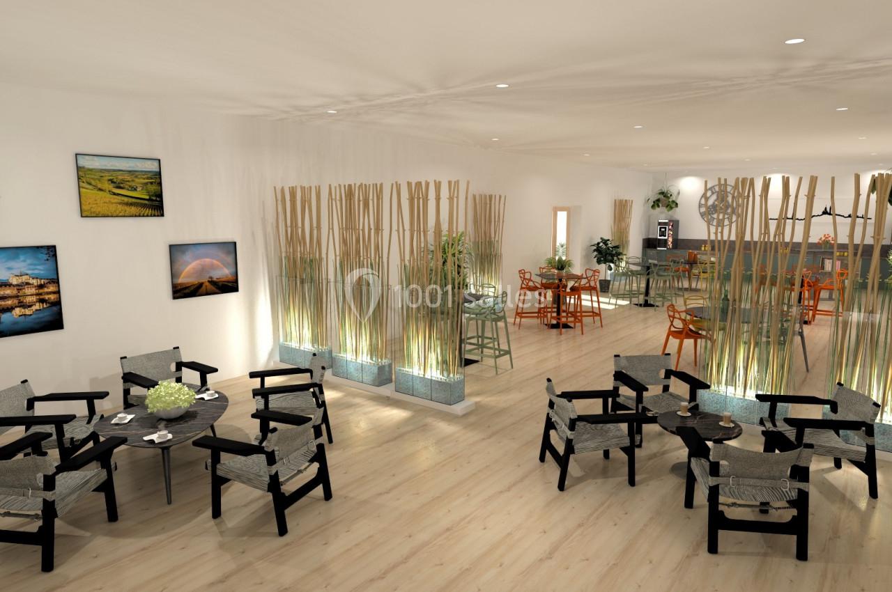 Salle lumineuse avec tables, chaises modernes, séparations en bambou et décorations murales naturelles.