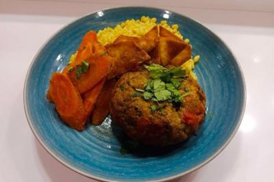 Assiette de fruits de mer variés avec moules, crevettes et quartiers de citron sur un lit de riz.