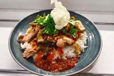 Assiette de fruits de mer variés avec moules, crevettes et quartiers de citron sur un lit de riz.