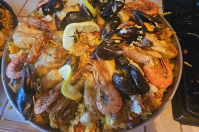 Assiette de fruits de mer variés avec moules, crevettes et quartiers de citron sur un lit de riz.