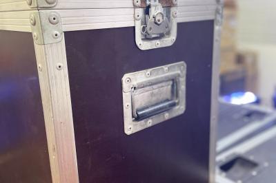 Enceintes de sonorisation empilées dans une configuration de type line array, partiellement couvertes par des housses.