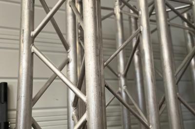 Enceintes de sonorisation empilées avec des grilles métalliques noires et une housse de protection partiellement visible.