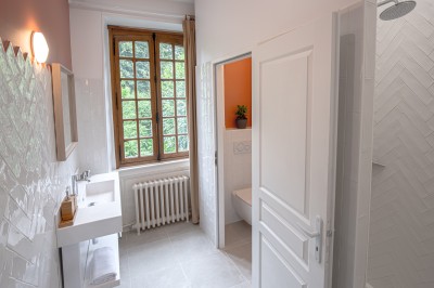 Miniature Location salle Villotran (Oise) - Au Vieux Château #24 Pelouse verdoyante entourée d'arbres sous un ciel dégagé, avec des pierres anciennes visibles au premier plan.