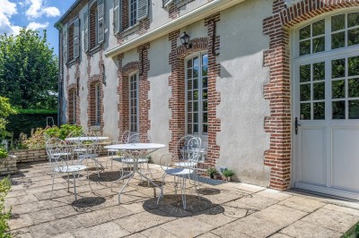 Miniature Location salle Villotran (Oise) - Au Vieux Château #15 Pelouse verdoyante entourée d'arbres sous un ciel dégagé, avec des pierres anciennes visibles au premier plan.