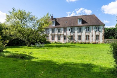 Miniature Location salle Villotran (Oise) - Au Vieux Château #5 Pelouse verdoyante entourée d'arbres sous un ciel dégagé, avec des pierres anciennes visibles au premier plan.