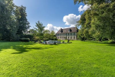 Miniature Location salle Villotran (Oise) - Au Vieux Château #11 Pelouse verdoyante entourée d'arbres sous un ciel dégagé, avec des pierres anciennes visibles au premier plan.