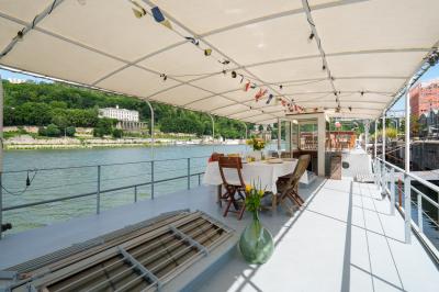 Poste de pilotage en bois d'un bateau avec un grand volant, des commandes et des fenêtres laissant entrer la lumière.