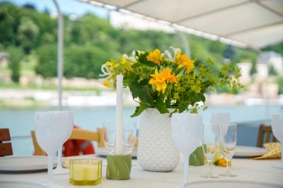Poste de pilotage en bois d'un bateau avec un grand volant, des commandes et des fenêtres laissant entrer la lumière.