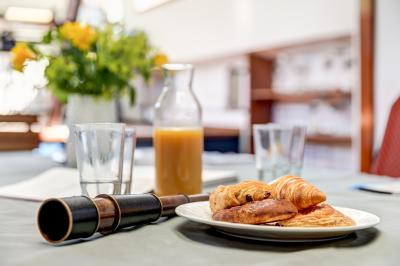 Poste de pilotage en bois d'un bateau avec un grand volant, des commandes et des fenêtres laissant entrer la lumière.