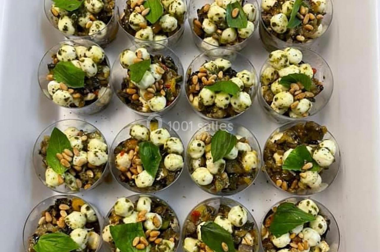 Coupes individuelles garnies de billes de mozzarella, pesto, pignons de pin, légumes grillés et feuilles de basilic.