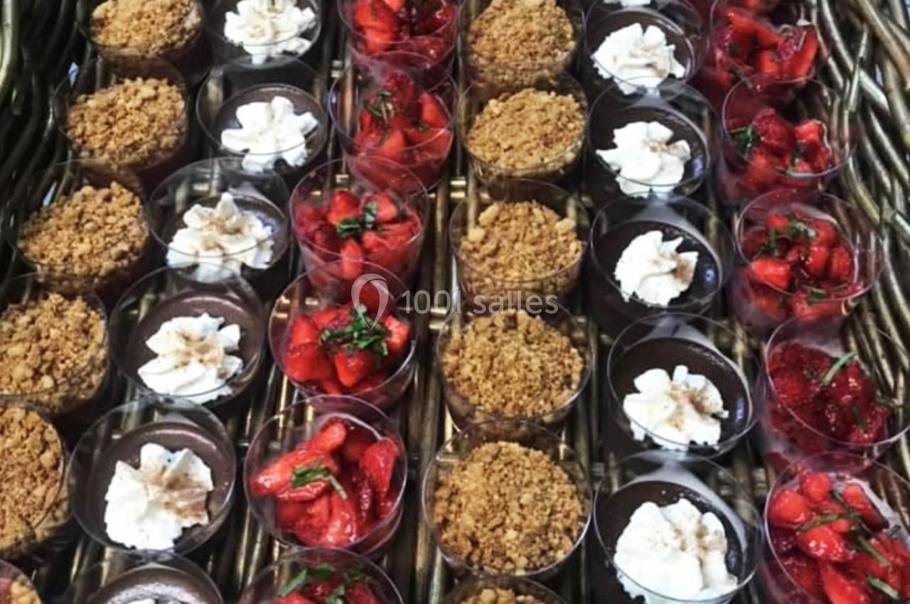 Desserts variés en verrines alignées, comprenant crumble, chocolat, fraises et crème fouettée.