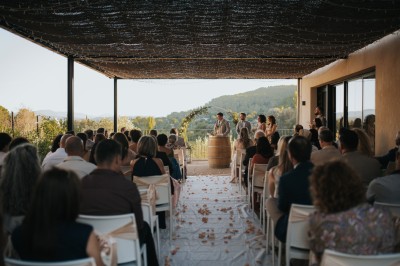 Salle lumineuse avec un sol en béton ciré, plafond en bois avec luminaires suspendus et murs décorés de motifs rouges.