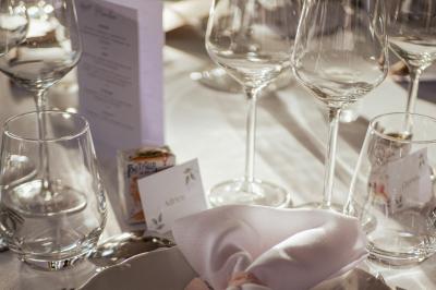 Costume de mariage bleu foncé avec chemise blanche et nœud papillon floral, suspendu sur un cintre gravé.