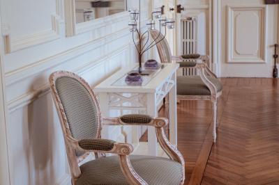 Costume de mariage bleu foncé avec chemise blanche et nœud papillon floral, suspendu sur un cintre gravé.