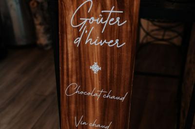 Costume de mariage bleu foncé avec chemise blanche et nœud papillon floral, suspendu sur un cintre gravé.