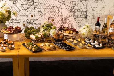 Assortiment de viennoiseries et fruits frais disposés sur un comptoir en métal dans un espace lumineux.