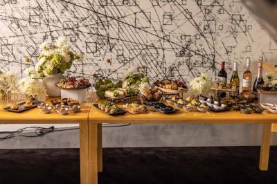 Assortiment de viennoiseries et fruits frais disposés sur un comptoir en métal dans un espace lumineux.