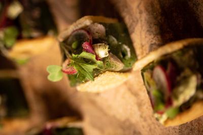 Assortiment de viennoiseries et fruits frais disposés sur un comptoir en métal dans un espace lumineux.