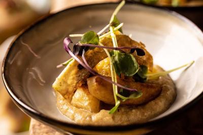 Assortiment de viennoiseries et fruits frais disposés sur un comptoir en métal dans un espace lumineux.