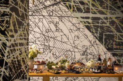 Assortiment de viennoiseries et fruits frais disposés sur un comptoir en métal dans un espace lumineux.