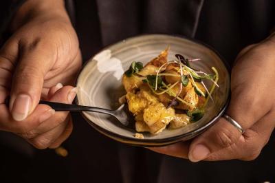 Assortiment de viennoiseries et fruits frais disposés sur un comptoir en métal dans un espace lumineux.