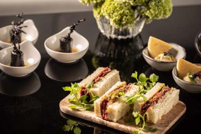 Assortiment de viennoiseries et fruits frais disposés sur un comptoir en métal dans un espace lumineux.