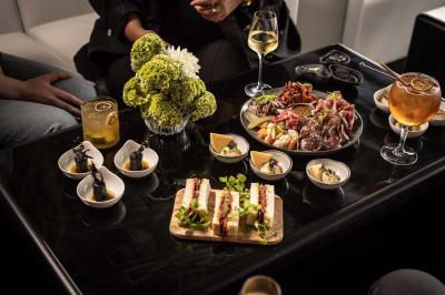 Assortiment de viennoiseries et fruits frais disposés sur un comptoir en métal dans un espace lumineux.