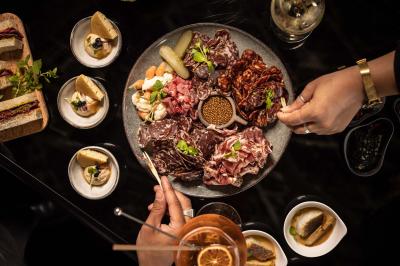 Assortiment de viennoiseries et fruits frais disposés sur un comptoir en métal dans un espace lumineux.