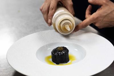 Assortiment de viennoiseries et fruits frais disposés sur un comptoir en métal dans un espace lumineux.